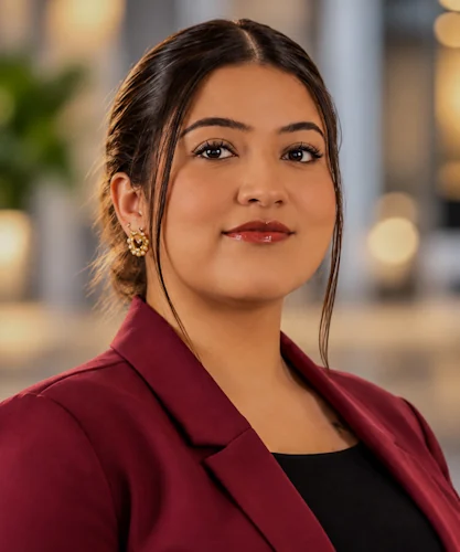 Woman in a burgundy blazer photographed against a softly blurred background