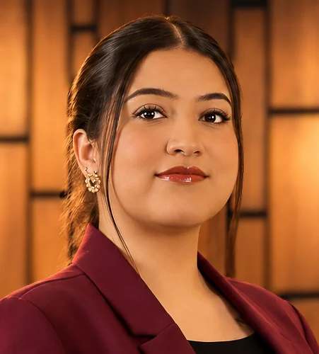 Woman in a burgundy blazer with warm interior lighting